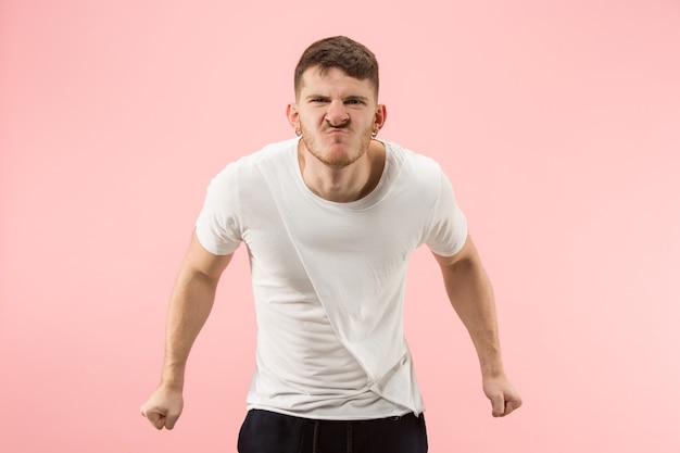 Free photo screaming, hate, rage. crying emotional angry man screaming on pink studio background. emotional, young face. male half-length portrait. human emotions, facial expression concept. trendy colors