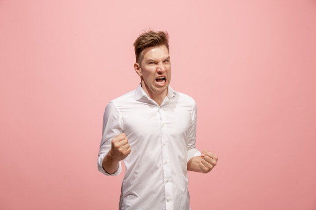 Free photo screaming, hate, rage. crying emotional angry man screaming on pink studio