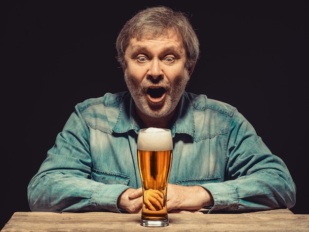 Free photo screaming man in denim shirt with glass of beer