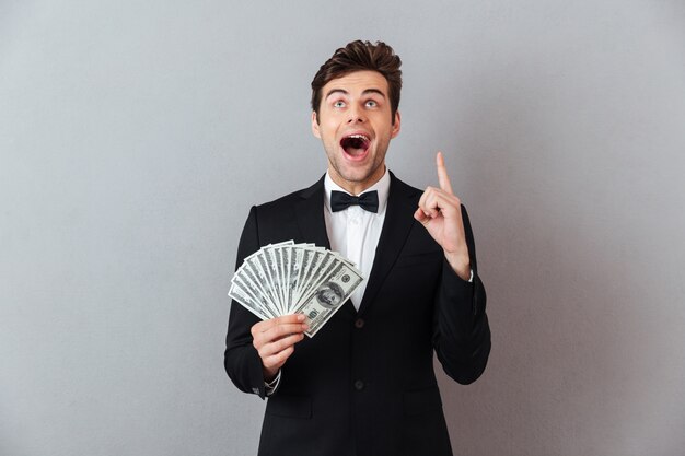 Screaming man in official suit holding money pointing.