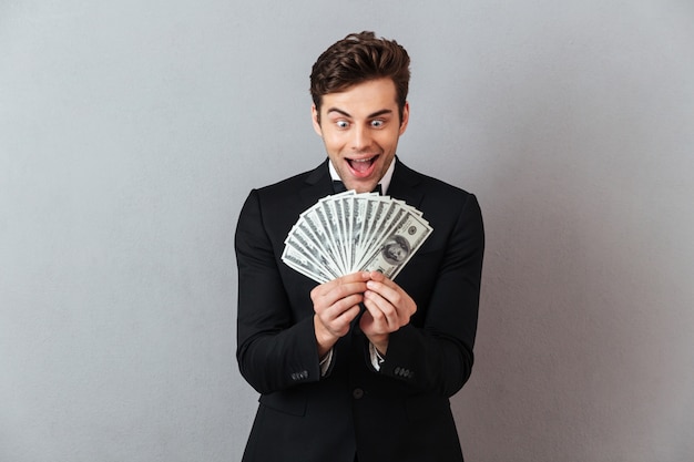 Screaming man in official suit holding money.