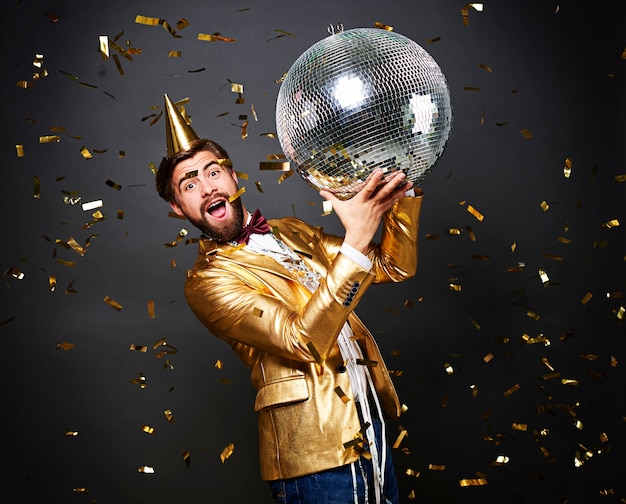 Screaming man with birthday hat holding disco ball 
