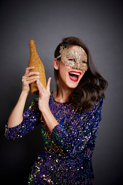 Screaming woman holding bottle of champagne