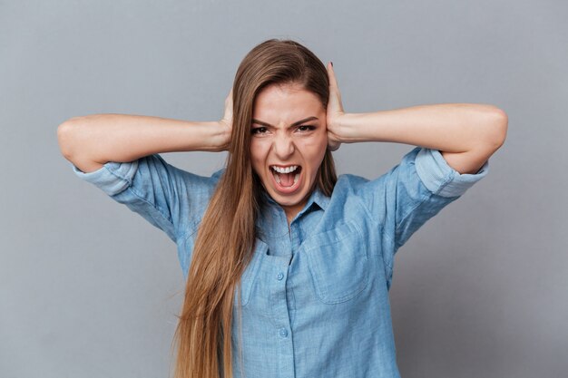 Foto gratuita urlando donna in camicia chiude le orecchie