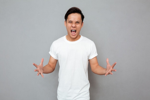 Screaming young asian man standing