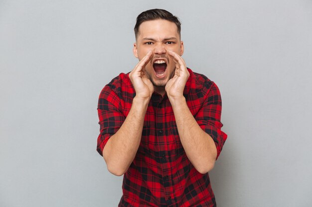 Screaming young man looking at camera.