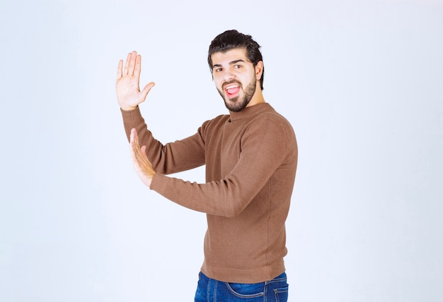 Free photo screaming young man model pushing invisible wall