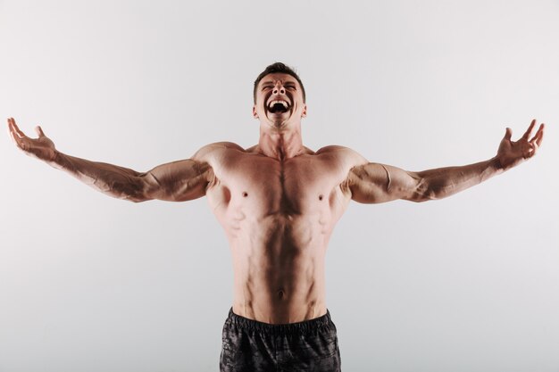 Screaming young sportsman standing with opened hands