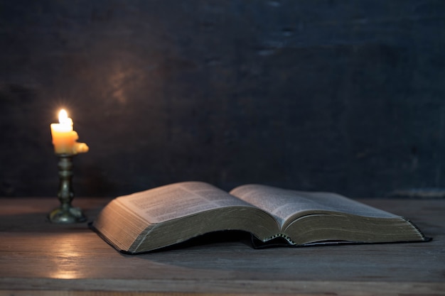 Священные Писания и свечи на деревянном столе