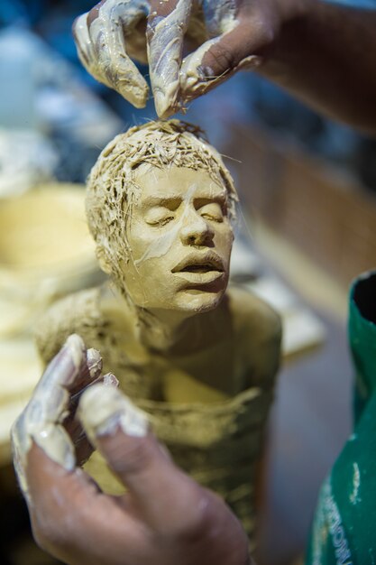 Sculptor making human body model with clay