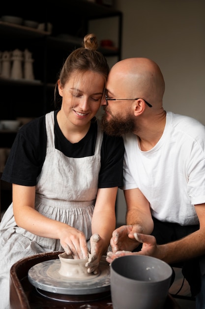 Sculptors couple working with clay in the studio together