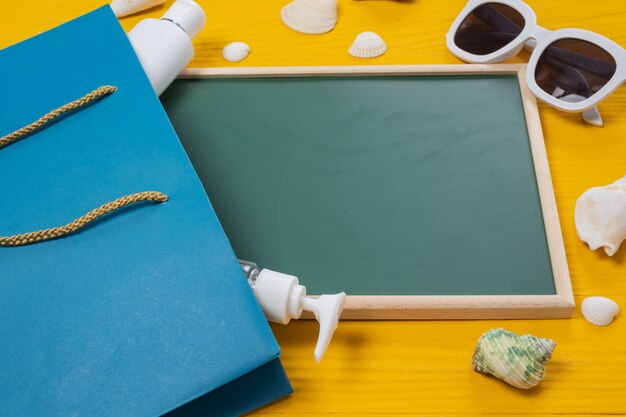 Sea tourism , a green writing board placed with various objects on a yellow wooden floor.