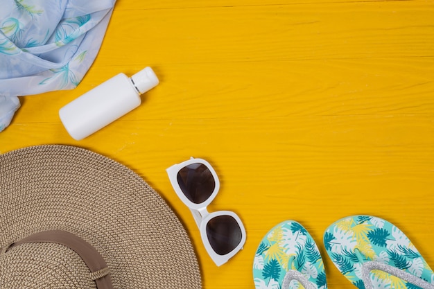 Sea travel , hat, sunglasses, glasses, sandals Laid on a yellow wooden floor.