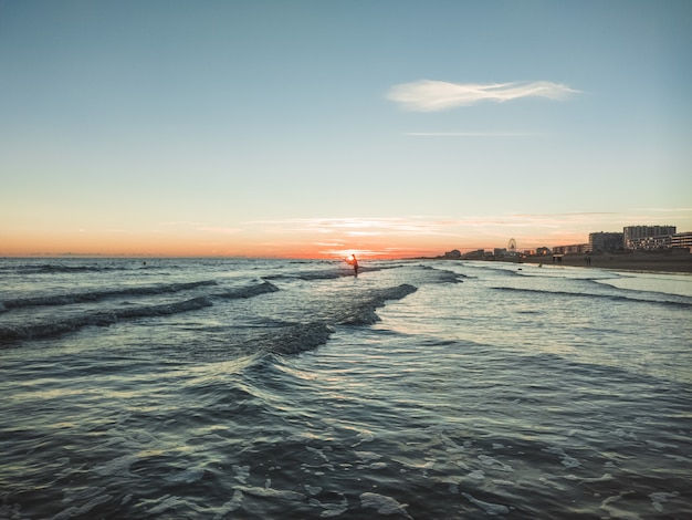 美しい日没時に海の波