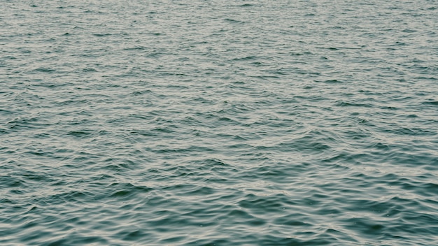 Бесплатное фото Море с красивыми волнами и каплями дождя, падающими на поверхность