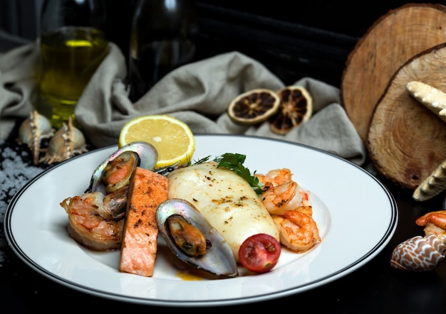 Seafood plate with fried salmon, mussels, shrimps, calamari and lemon