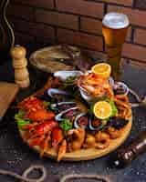 Free photo seafood plate with shrimps, mussels, lobsters served with lemon and glass of beer