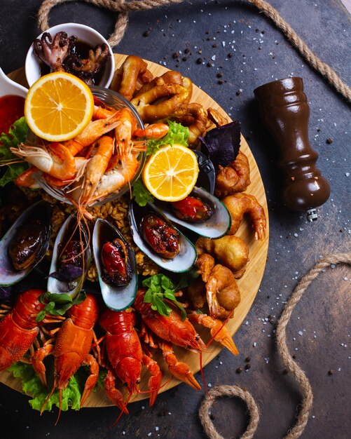 Тарелка с морепродуктами с креветками, мидиями и лобстерами с лимоном