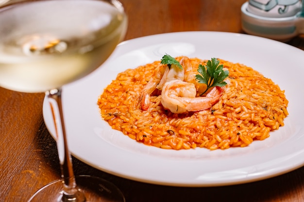 Seafood risotto with tomato sauce garnished with shrimp