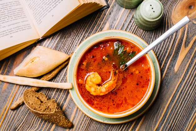 Суп из морепродуктов креветки томатный хлеб вид сверху