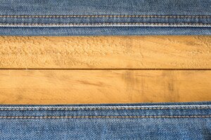 Бесплатное фото Шов голубых джинсов на деревянной текстуре