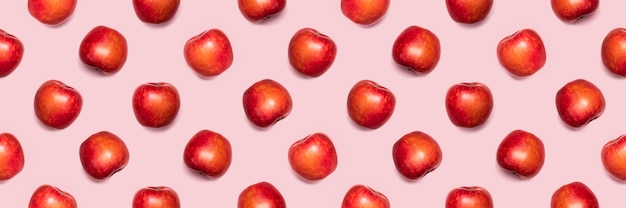 Seamless pattern from apples on a pink background.