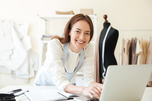 Seamstress using laptop for work