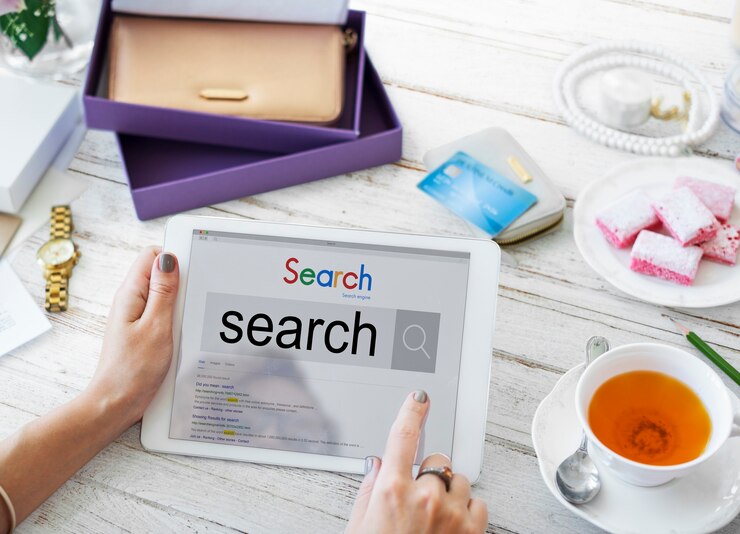 Personne utilisant une tablette affichant un moteur de recherche, symbolisant la recherche d’informations optimisées grâce à l’on-page seo.