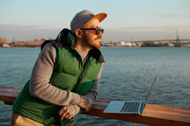 In search of inspiration. Outdoor picture of handsome fashionable guy with neat beard