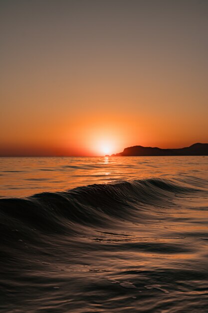 澄んだ空と夕日の波と海の風景