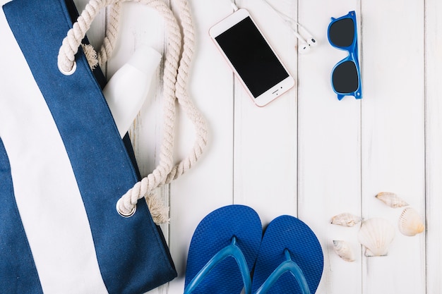 Seashells and smartphone near vacation stuff