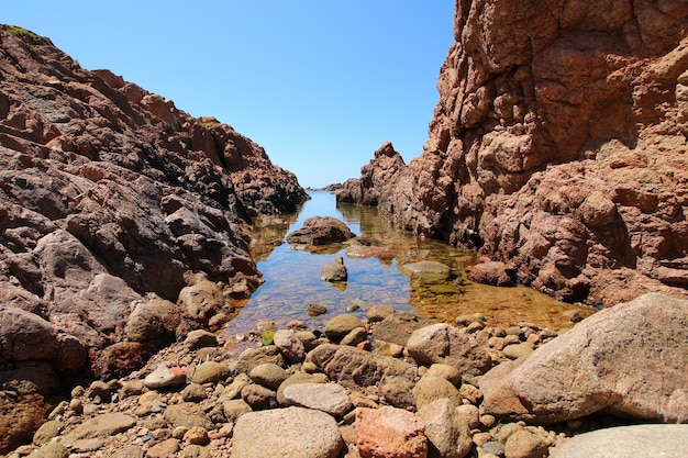 Seashore surrounded by rocks and the sea under the sunlight