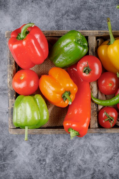 Seasonal color bell peppers in a rustic tray. Top view.