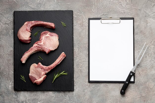 Seasoned meat on wooden board and clipboard