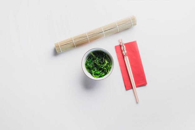 Seaweed salad near chopsticks and napkin