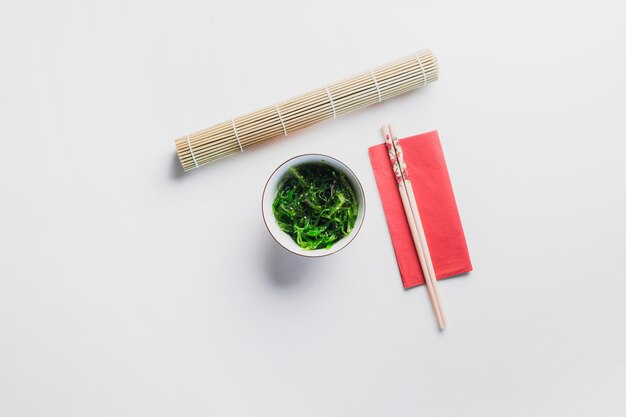 Seaweed salad near chopsticks and napkin