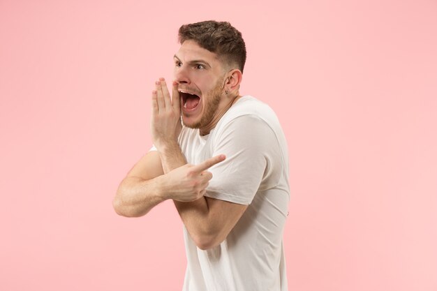 Secret, gossip concept. Young man whispering a secret behind his hand.