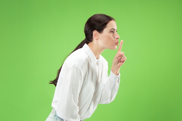 Free photo secret, gossip concept. young woman whispering a secret behind her hand.