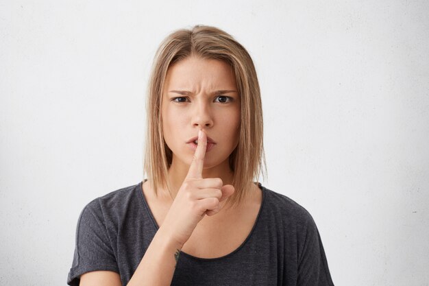 沈黙の兆しを見せている秘密の女性。大きな音でイライラする沈黙を求めるとんでもない若い女性