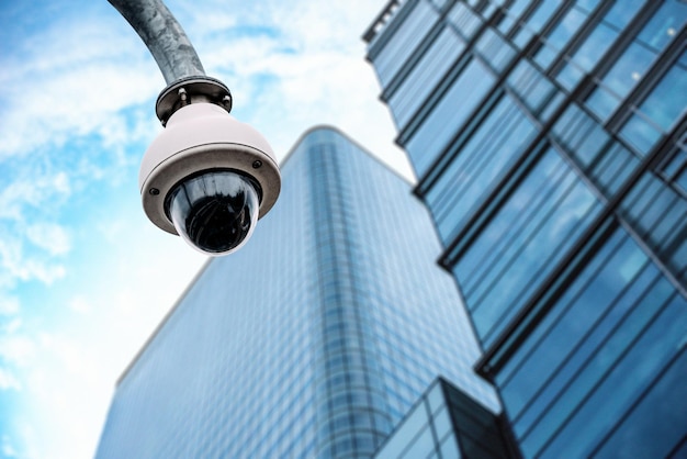 Free photo security camera with a glass building on the background