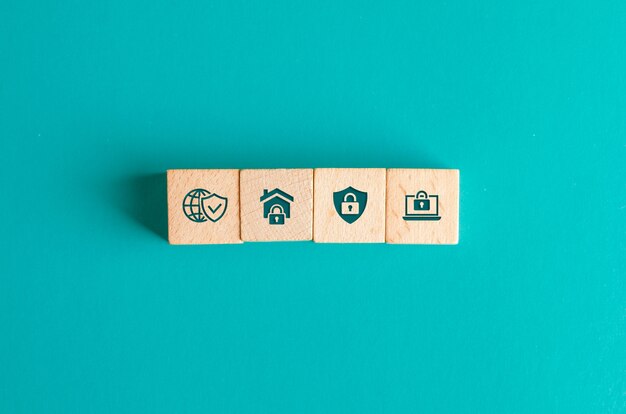 Security concept with icons on wooden blocks on turquoise table flat lay.