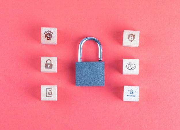 Security concept with lock, icons on wooden cubes on pink table flat lay.