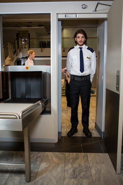 Security guard standing under the scanning door