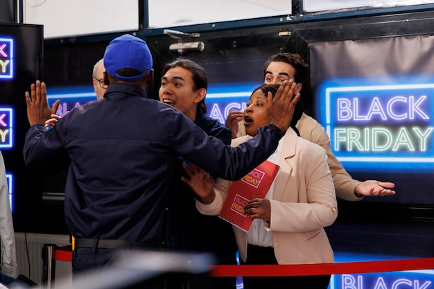 Foto gratuita agente di sicurezza che trattiene gli acquirenti ansiosi che aspettano il lancio delle vendite del black friday, persone diverse clienti in fila all'ingresso del negozio durante le vendite stagionali, urlando e urlando