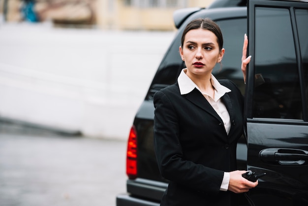 Foto gratuita automobile di apertura della donna di sicurezza per clientt