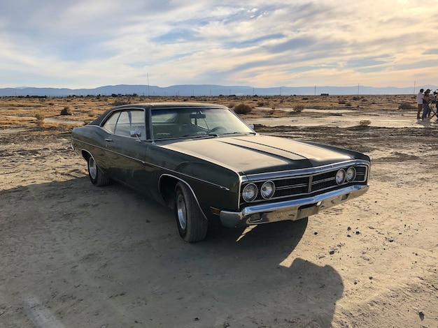 Free photo sedan parked at a deserted area under a cloudy sky