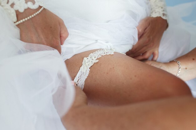 Seductive bride puts on white garter