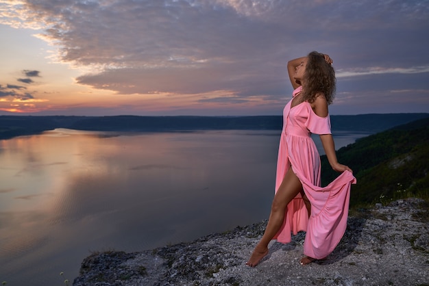 Seductive girl posing on background of beautiful landscape