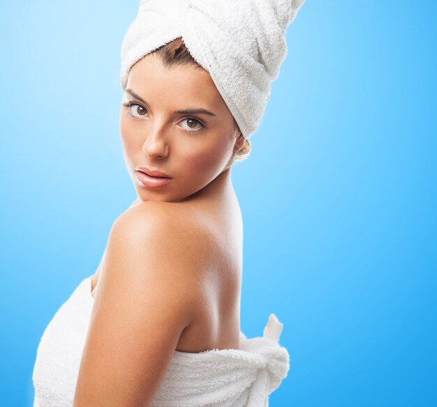 Seductive girl in towel against blue background