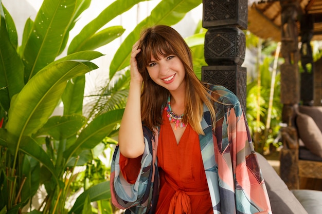 Seductive stylish woman in bohemian summer clothes  posing in tropical luxury resort. Vacation  concept.